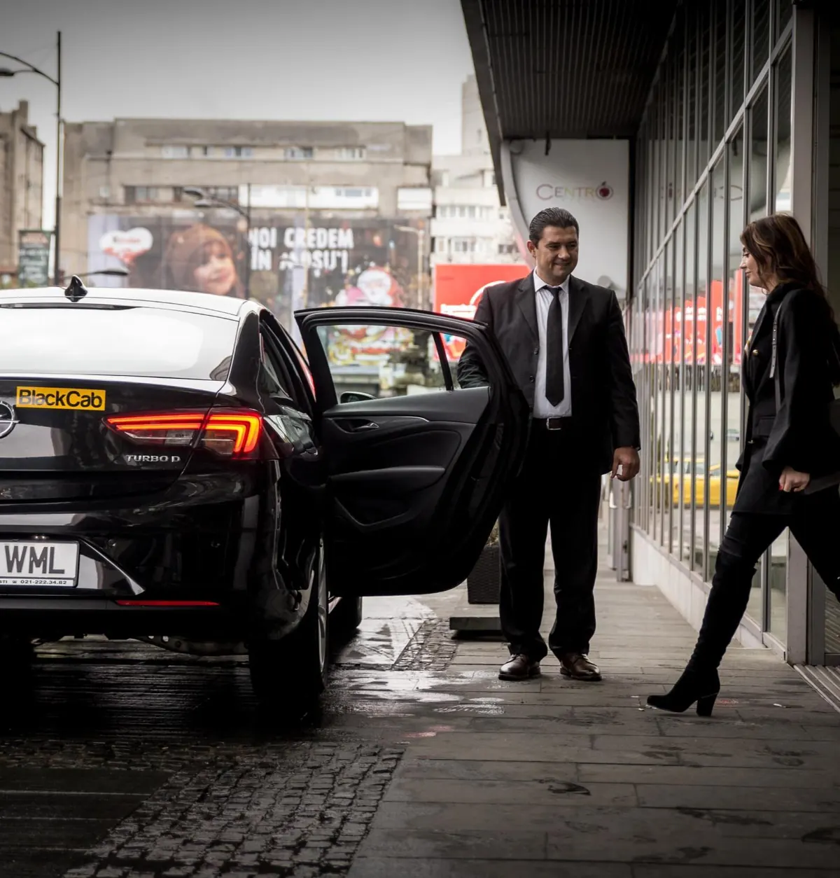 Sofer BlackCab deschizand usa unei pasagere